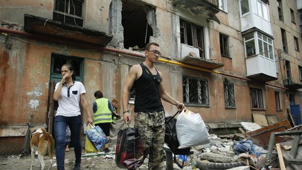 Varias personas sacan escombros de una vivienda afectada por un bombardeo en Gorlovka, en el area de Donestsk