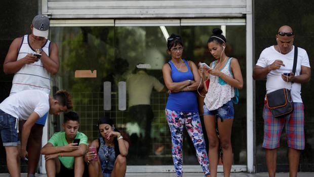 Ciudadanos cubanos usando sus teléfonos móviles