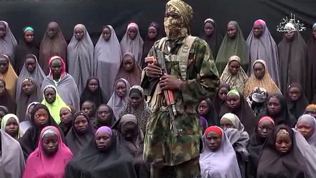 Imagen difundida el pasado mes de agosto por Boko Haram, en la que se observa, junto al yihadista, a un grupo de las estudiantes de Chibok secuestradas en 2014