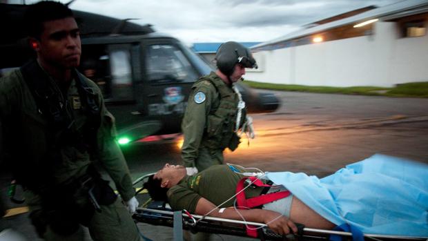 Soldados colombianos trasladan a un compañero que cayó en un campo minado en el departamento de Antioquia, noroeste del país