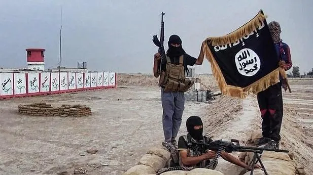 Foto de archivo de combatientes de Daesh muestran una bandera de la organización terrorista