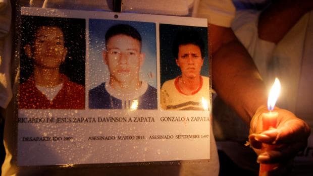 Fotos de desaparecidos o asesinados durante el conflicto interno colombiano, exhibidas durante una marcha por la paz este viernes en Medellín