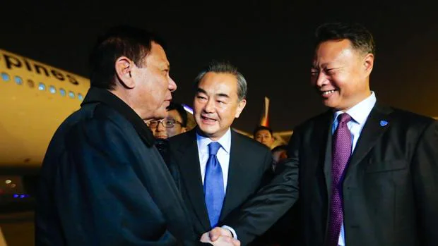 Duterte junto al ministro chino de Exteriores, en el centro, a su llegada a Pekín
