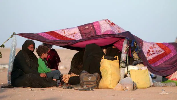 Un grupo de civiles que lograron huir de Mosul, descansan tras cruzar la frontera con Siria