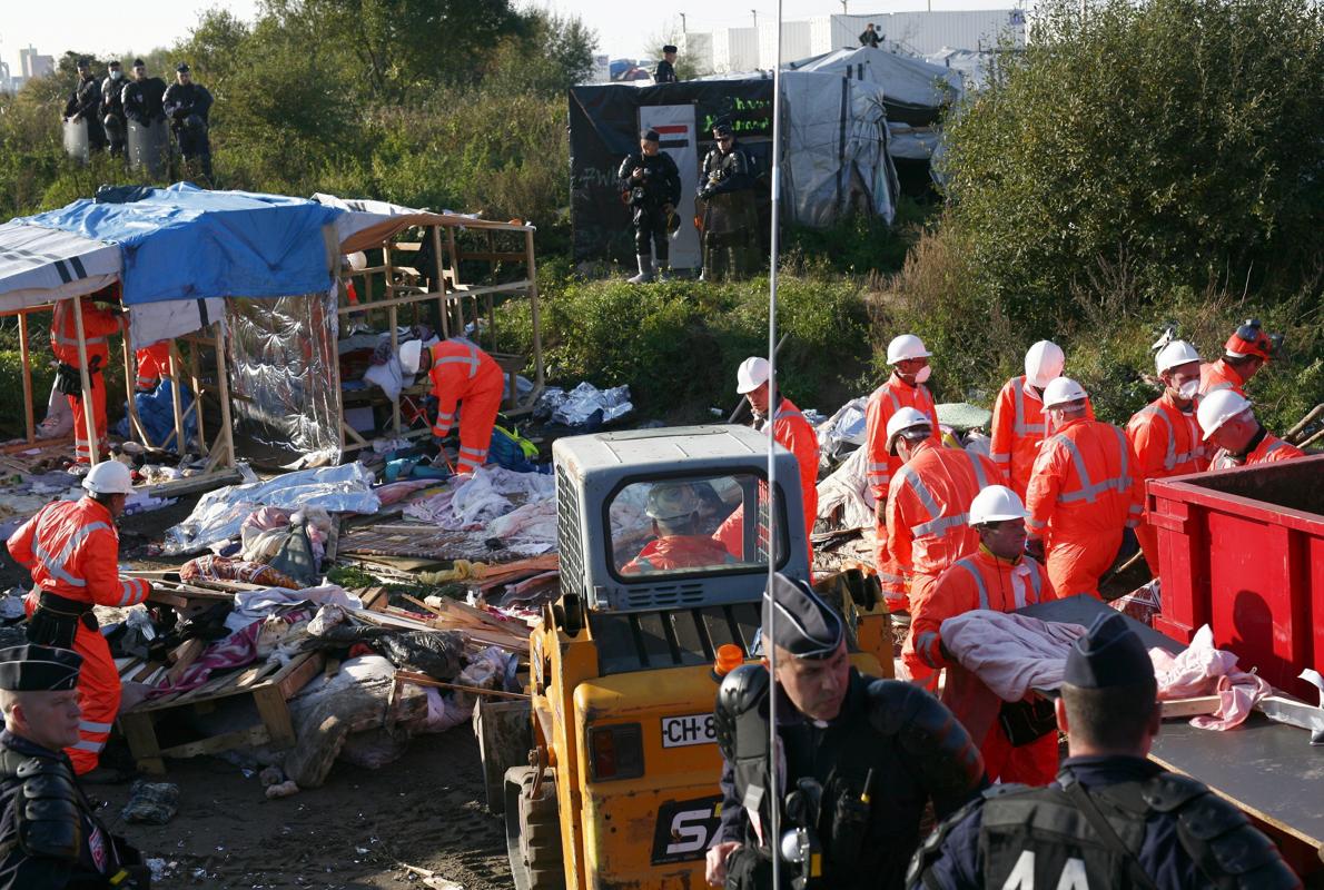 Agentes de policía galos permanecen junto a un grupo de trabajadores durante la segunda jornada de evacuación