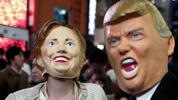 Dos personas posan disfrazadas de la candidata demócrata y del candidato republicano