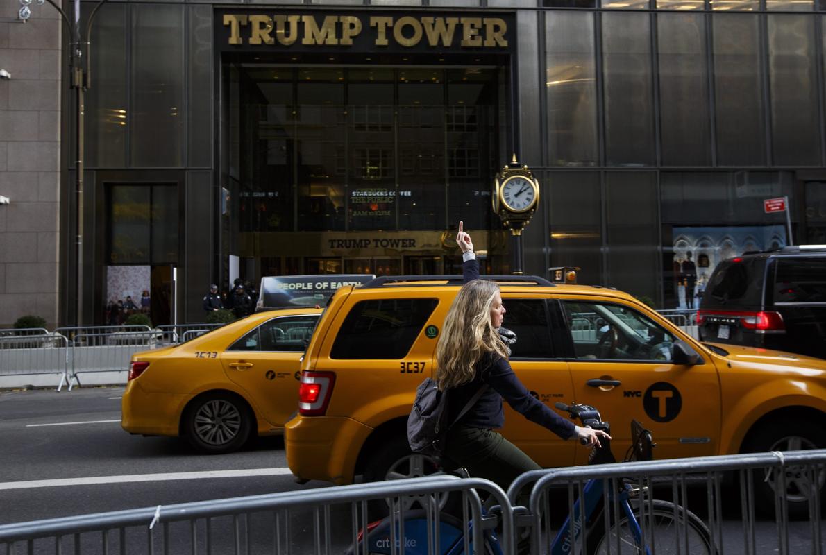 Una mujer realiza una seña obscena frente al edificio Torre Trump