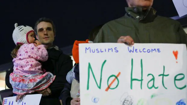 Manifestantes sostienen pancartas de protesta contra el presidente elcto, Donald Trump, y en apoyo a los musulmanes este lunes en Hamtramck, Michigan
