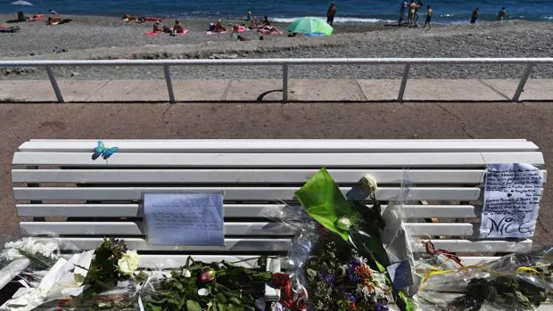 Flores sobre un banco del paseo de los Ingleses, en Niza, donde el pasado julio un atentado terrorista causó 86 muertos