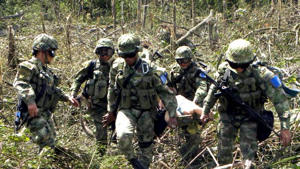 Soldados colombianos trasladan a un guerrillero del ELN tras un bombardeo a un campamento de la guerrilla