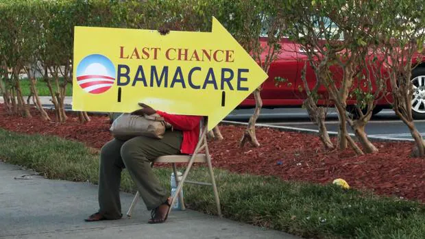 Una mujer sostiene un cartel sobre el «Obamacare», el modelo de cobertura sanitaria ideado por el presidente saliente de EE.UU., junto a hospital de Miami