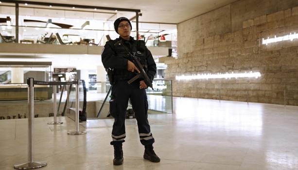 Un agente de policía galo permanece en guardia en el interior del Museo del Louvre, en París