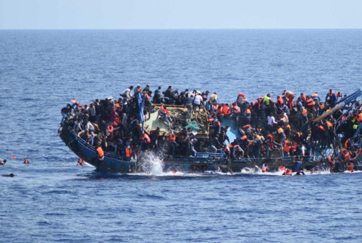 Un barco de inmigrantes salidos de las costas libias zozobra en el mar Mediterráneo
