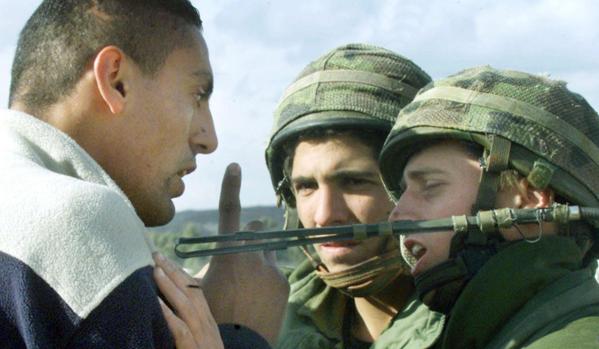Un palestino discute con soldados israelíes en un control militar en las afueras de Ramala, Cisjordania