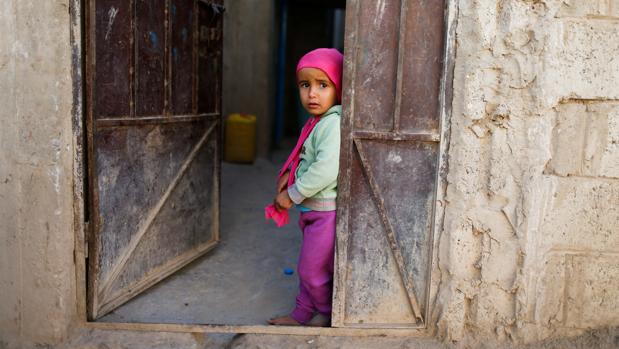 Una niña, en la puerta de su casa en Saná