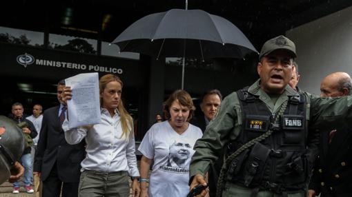 La esposa del opositor Leopoldo López, Lilian Tintori (i) y la esposa del alcalde de Caracas, Antonio Ledezma, Mitzy Capriles (c), junto a la Fiscalía General de Venezuela, en Caracas este lunes