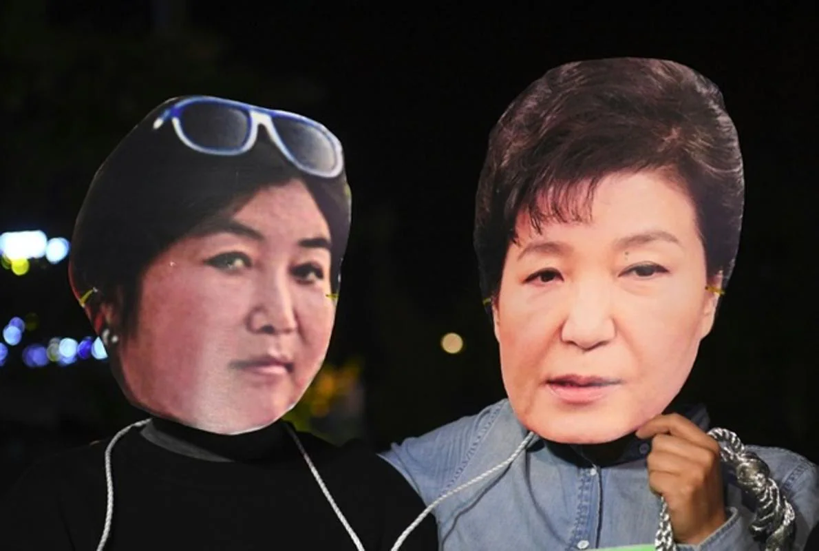 Manifestantes con máscaras de la presidenta de Corea del Sur (derecha) y de su confidente Choi Soon-Sil
