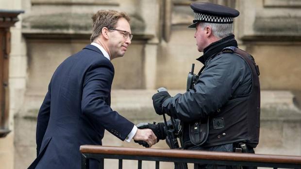 Tobias Ellwood recibe el saludo de un policía junto al Parlamento de Londres