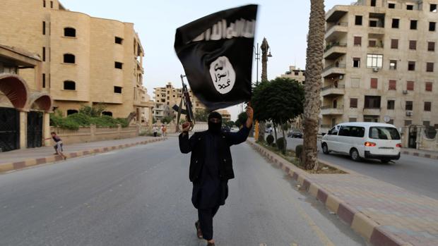 Un miembro de Daesh con una bandera en Raqqa en 2014