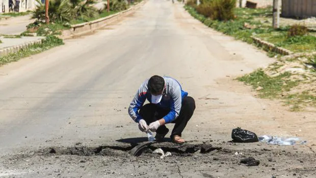 Un hombre recolecta muestras sobre el ataque en Siria