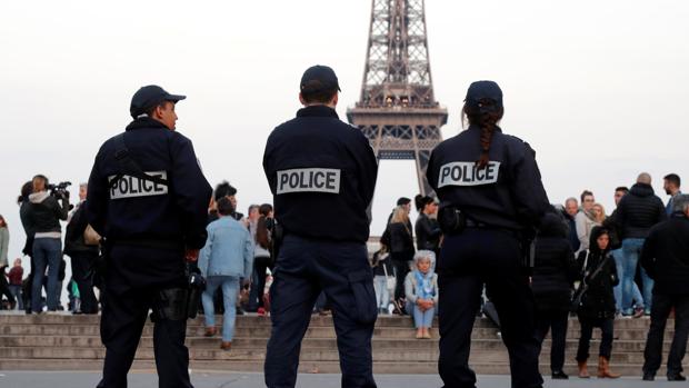 Tres policías franceses en labores de vigilancia, con la Torre Eiffel al fondo