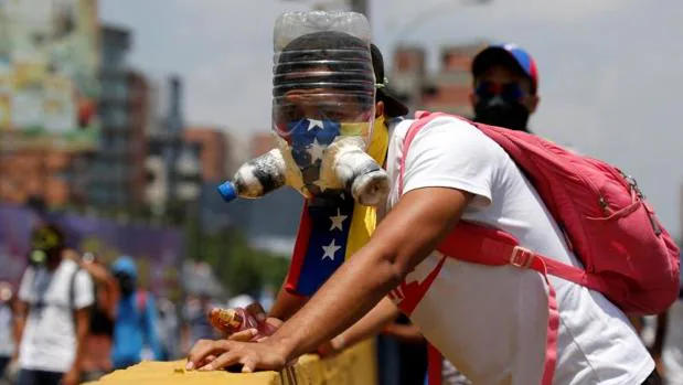 Un manifestante con una máscara artesanal para protegerse de los gases lacrimógenos, durante la protesta opositora de este miércoles en Caracas