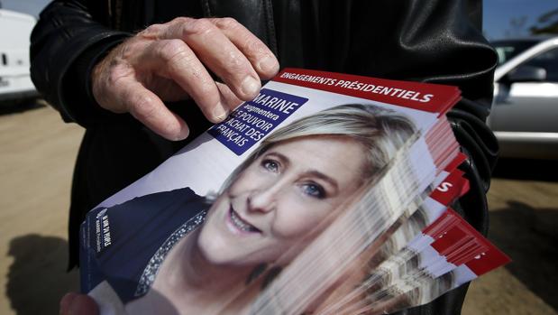 Una mujer reparte octavillas con el rostro de Le Pen en Valbonne, al sur de Francia