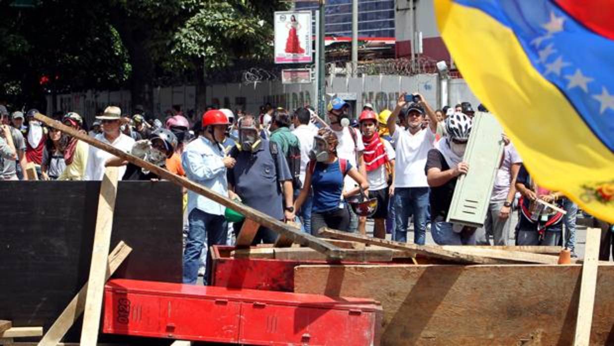 Manifestantes montan barricadas para impedir que la policía venezolana los saque de las calles durante una protesta opositora