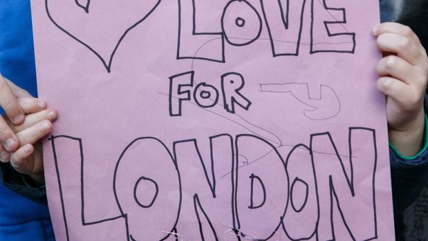 Un niño sostiene una pancarta para homenajear a las víctimas del atentado de Londres