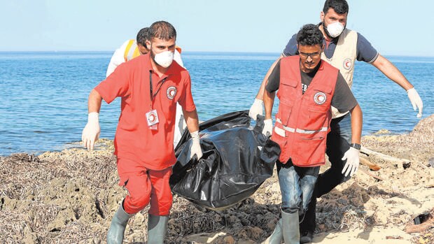 Miembros de la Cruz Roja, en Libia, recuperan cuerpos de inmigrantes ahogados en el Mediterráneo