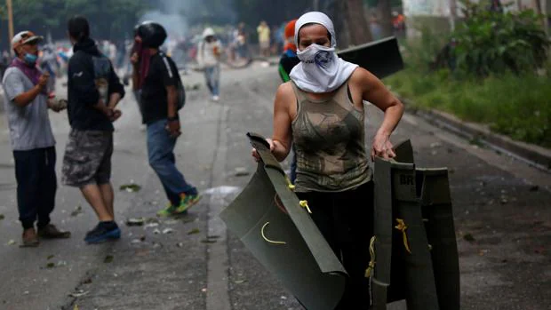 Un manifestante porta varios escudos para protegerse de la guardia bolivariana durante una huelga convocada para protestar contra el gobierno del presidente venezolano, Nicolás Maduro, en Caracas, Venezuela