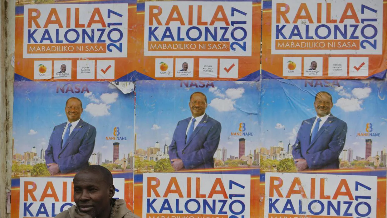Un hombre descansa junto a un cartel electoral del líder opositor keniata Raila Odinga en Nairobi