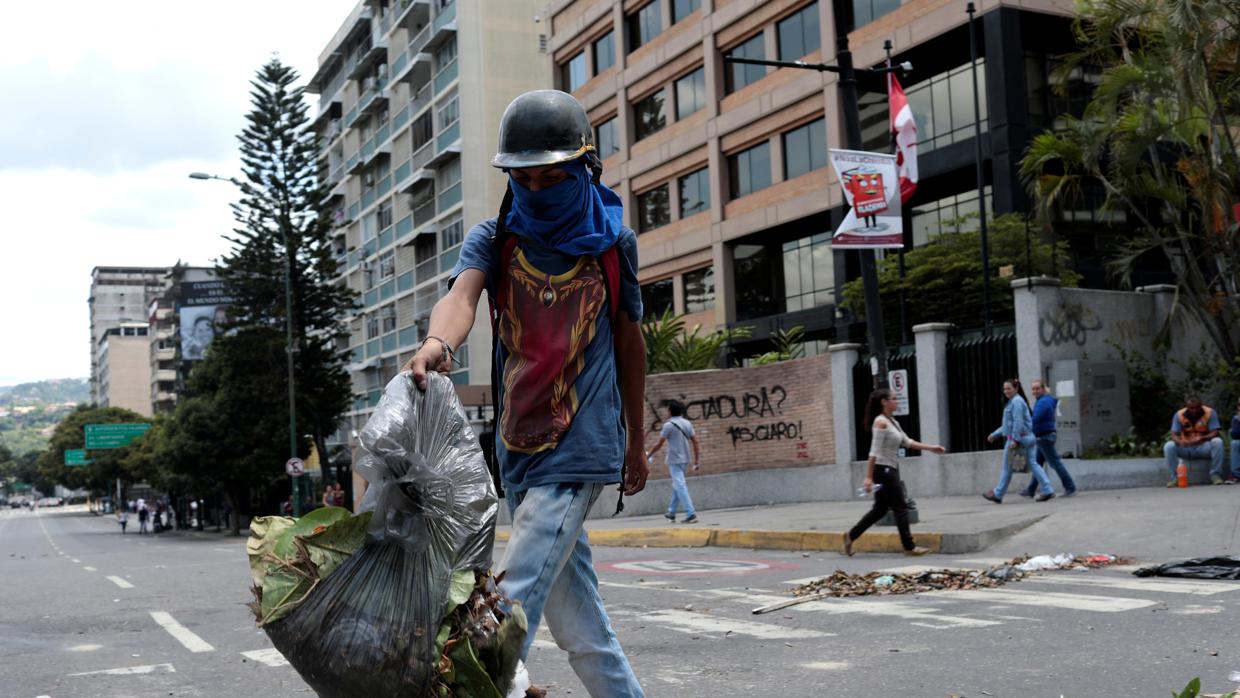 Un manifestante bloquea una calle de Caracas