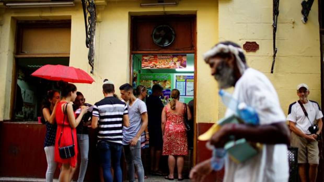 Un grupo de cubanos frente a un restaurante privado en La Habana