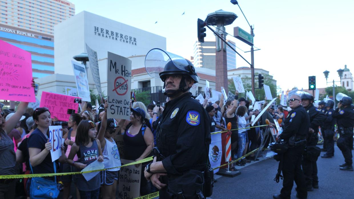 Manifestantes protestan a las puertas del Centro de Convenciones de Phoenix donde Donald Trump ofrece un mitin