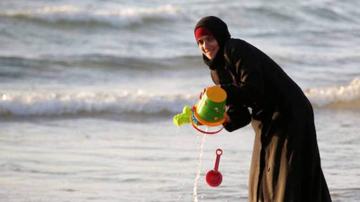 Una mujer viste un hijab en una playa de Israel