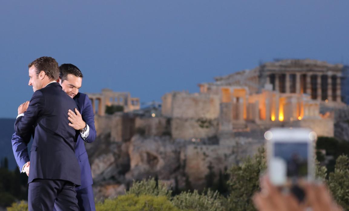 Emmanuel Macron y Alexis Tsipras se abrazan frente a la Acrópolis de Atenas