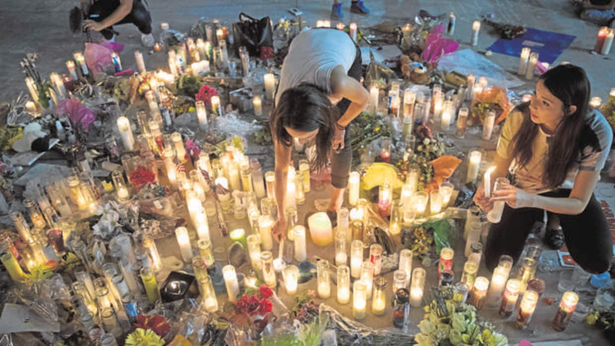 Dos jóvenes encienden velas en el memorial por las víctimas del tiroteo en Las Vegas