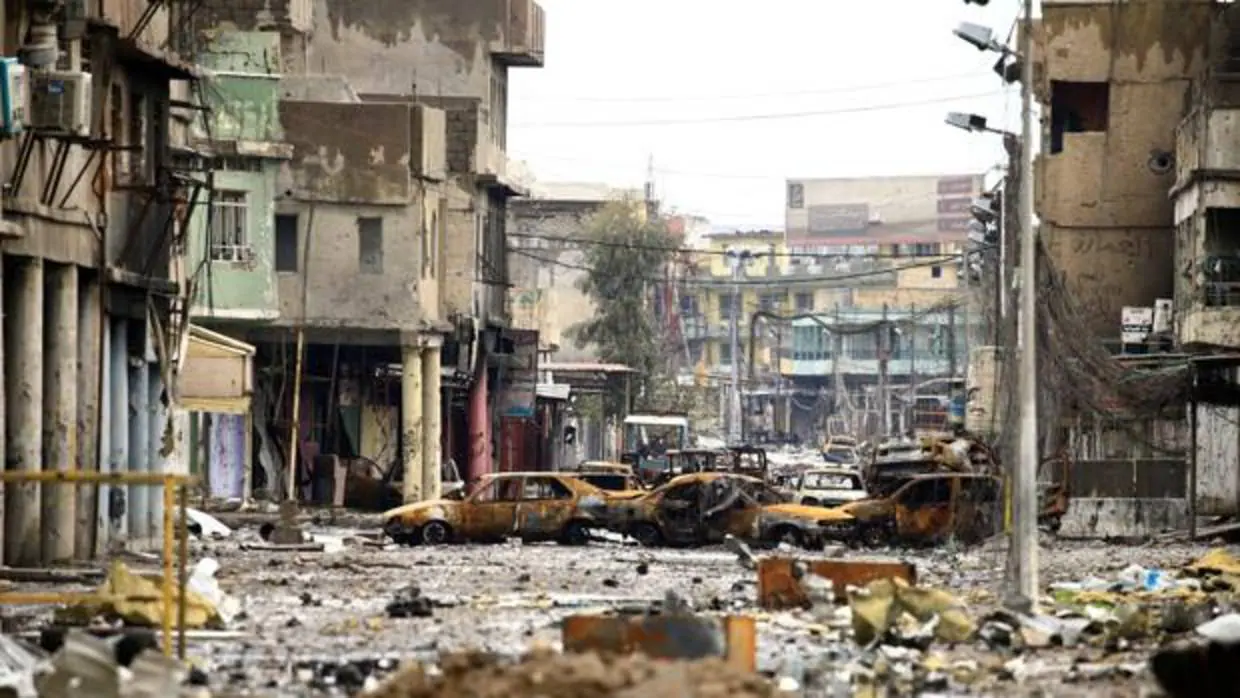 Coches y viendas destruidas tras un enfrentamiento entre soldados del Ejército iraquí y del Daesh