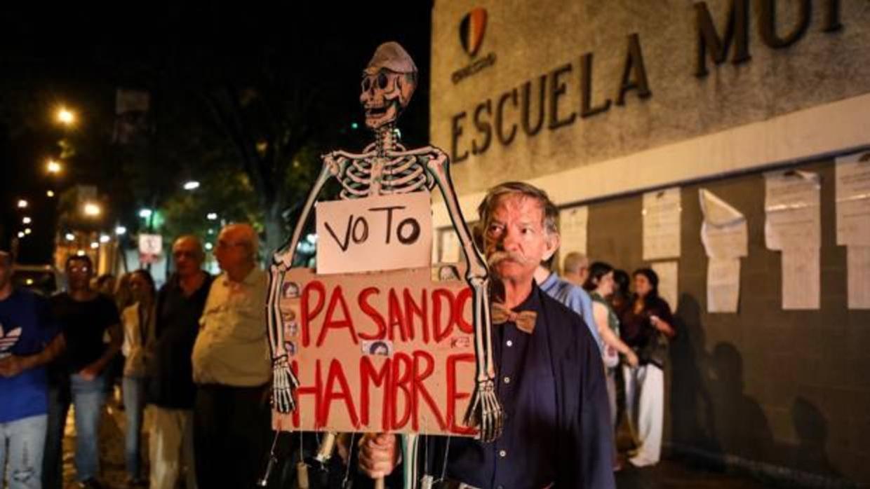 Un hombre protesta al cierre de los colegios en las elecciones regionales de Venezuela este domingo