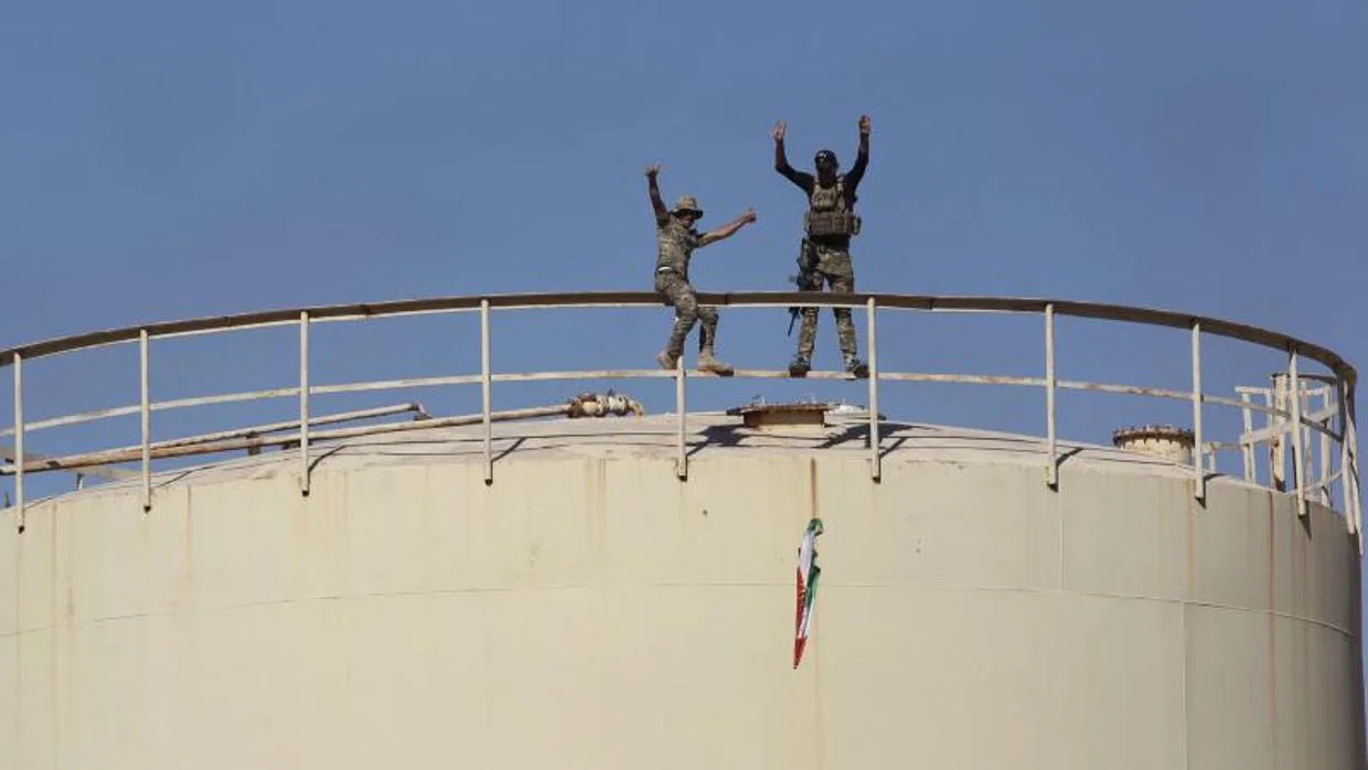 Fuerzas iraquíes retiran una bandera kurda del campo petrolífero de Bai Hassan, al oeste de Kirkuk (norte de Irak)