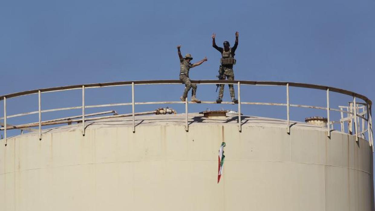 Fuerzas iraquíes retiran una bandera kurda del campo petrolífero de Bai Hassan, al oeste de Kirkuk (norte de Irak)