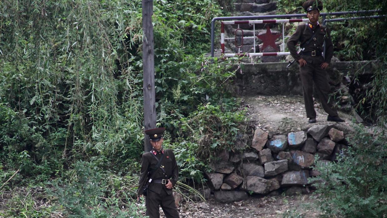 Fusil en ristre, los soldados norcoreanos vigilan la frontera con China en el río Yalu a su paso por Dandong
