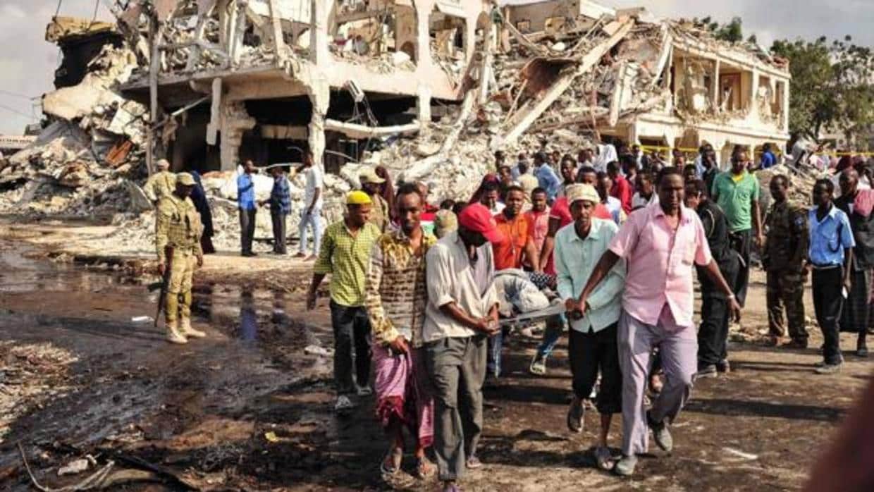 Unos hombres portan a una víctima de un atentado con camión bomba en Mogadiscio (Somalia) el pasado octubre