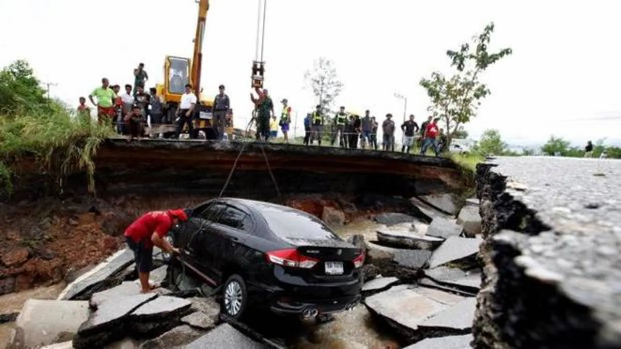 Oficiales tailandeses rescatan un coche en un paso derrumbado