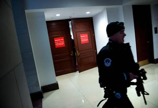 Un agente de seguridad vigila la puerta donde tiene lugar la declaración de Donald Trump Jr. ante el Congreso