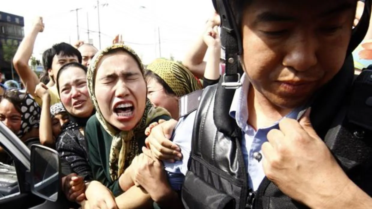 Manifestantes pertenecientes al grupo minoritario musulmán uigur se enfrentan con la policía