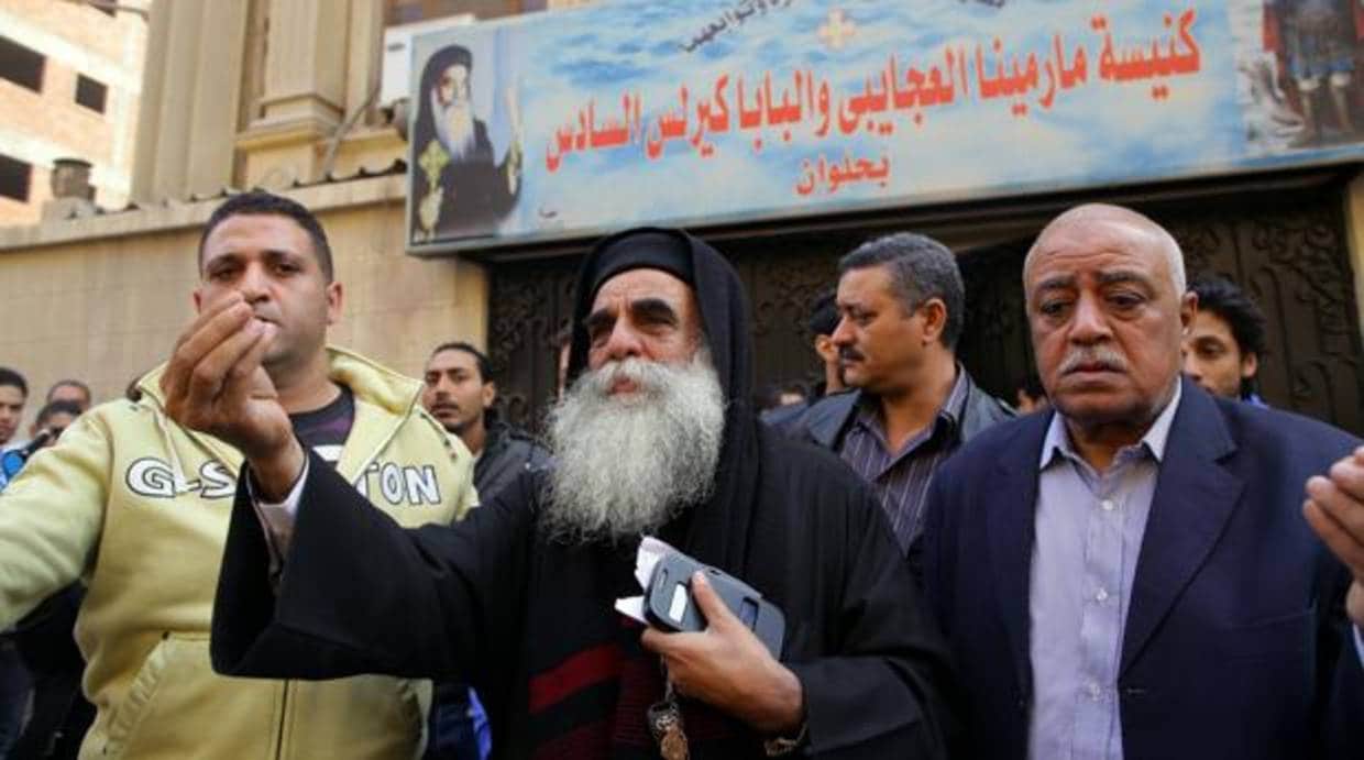 El sacerdote Andoras Azmey habla con la gente tras el atentado de ayer en una iglesia del sur de El Cairo