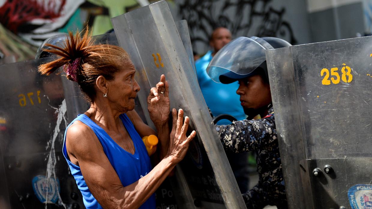 Fotografía de archivo en la que una mujer se enfrenta a los antidisturbios en una protesta contra la escasez de alimentos