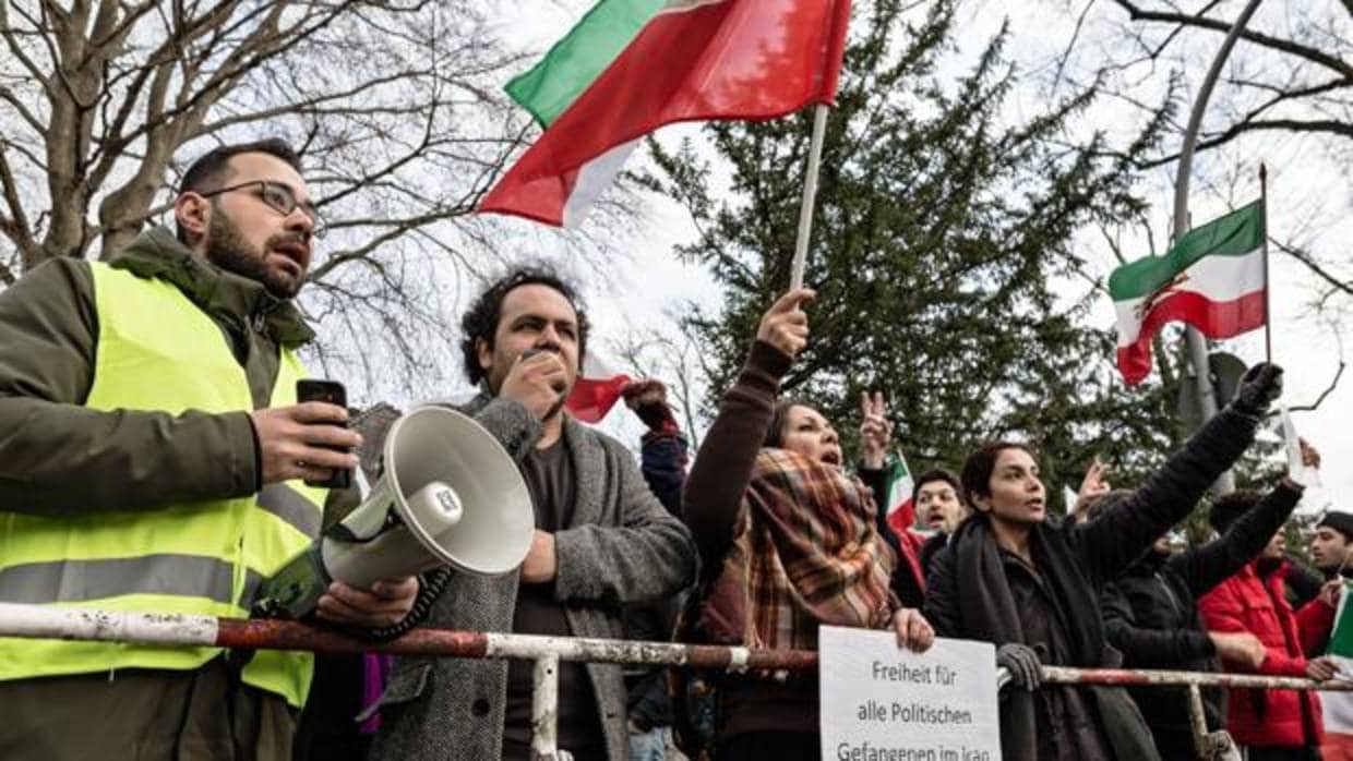 Manifestantes ondean banderas de la era de la monarquía constitucional iraní durante una protesta en la embaja de Irán en Berlín